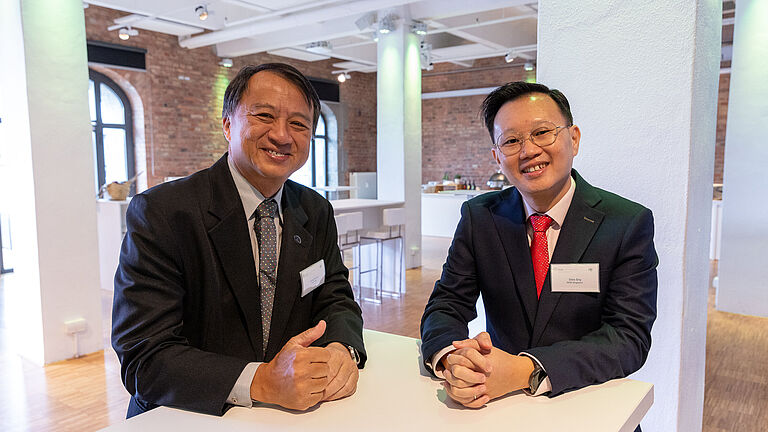 Gruppenbild mit Siong Hin Ho (links), Präsident der IVSS Sektion Handel, und seinem designierten Nachfolger Silas Sng beim ISSA-Symposium 2022 in Berlin